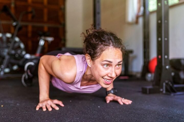 Woman performs push-up in garage gym