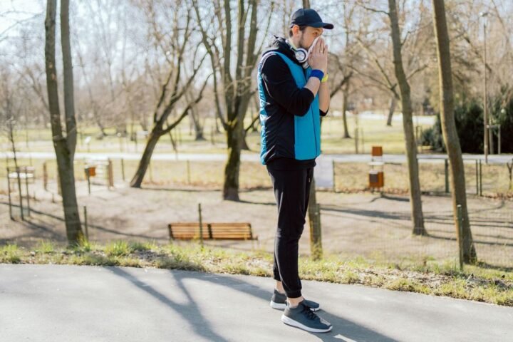 Runner in park blows nose