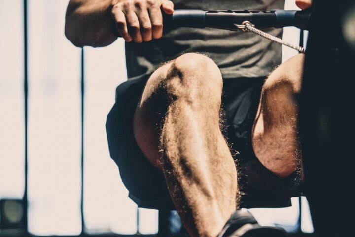 Unrecognisable man using rowing machine